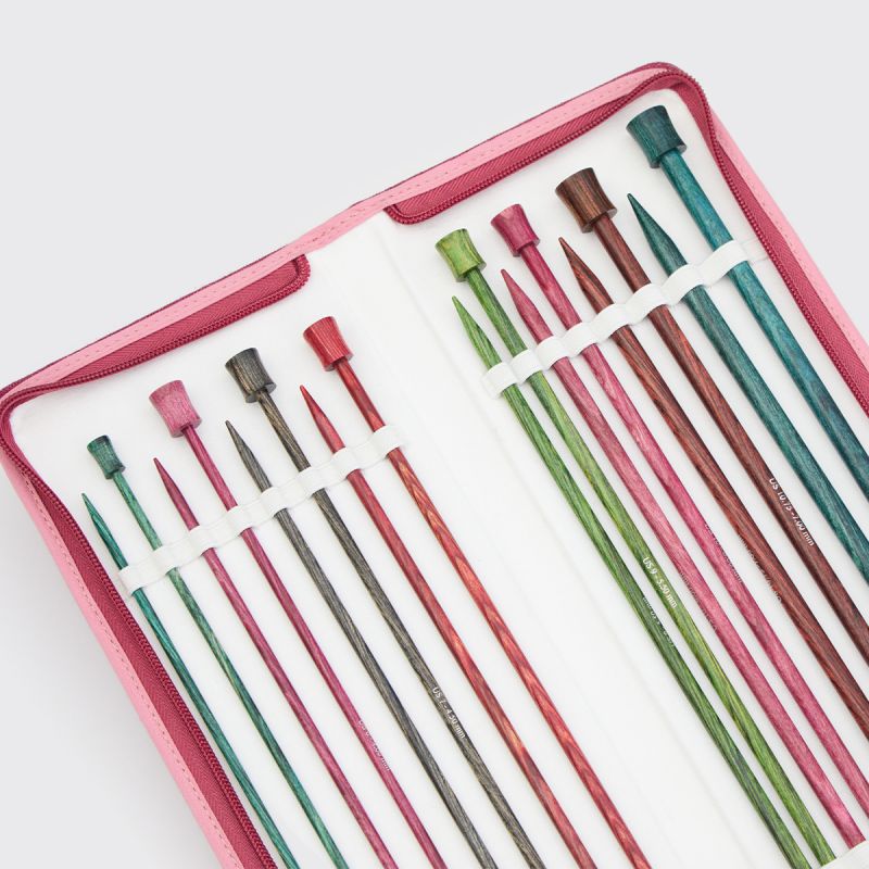 Close view of eight colour-coded KnitPro Dreamz 25cm straight needle pairs inside the open case