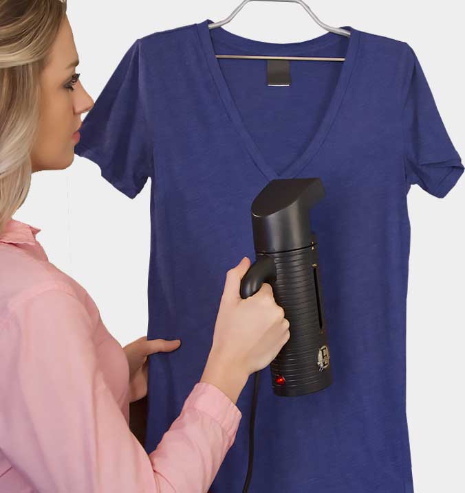 Jiffy ESTEAM handheld steamer removing wrinkles from a blue shirt
