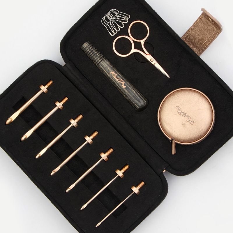 Close view of seven KnitPro Oasis Starter hook heads with wooden handle, tape, scissors and locking stitch markers