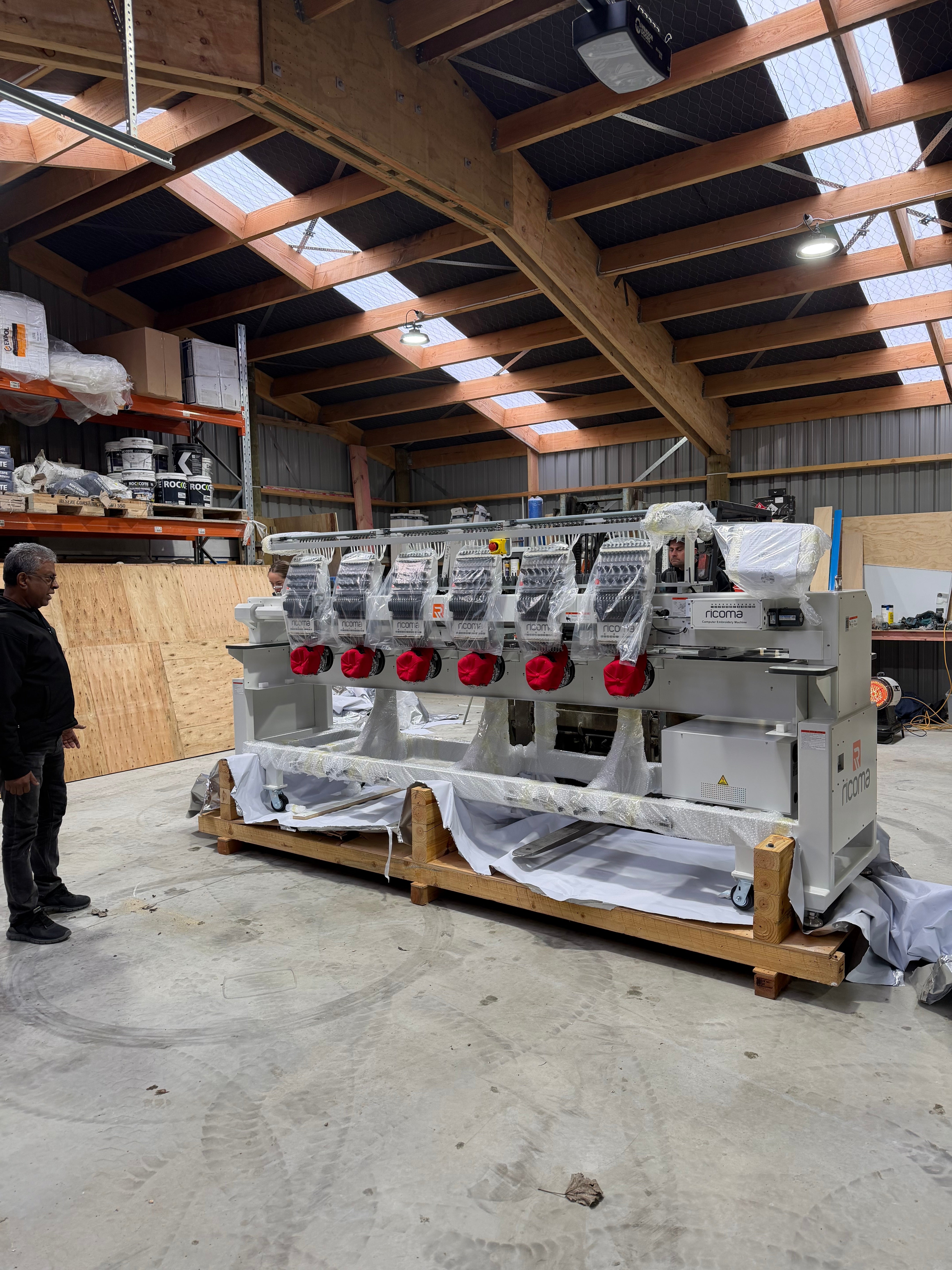 The six-head Ricoma commercial embroidery machine being unpacked during installation in Alexandra